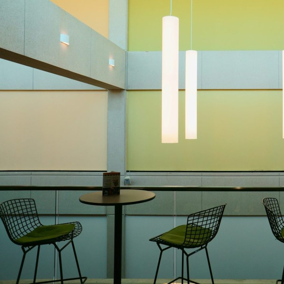 Lampen und Stühle Moderne Innenarchitektur mit hängenden Lampen und stilvollen Stühlen an einem Tisch.